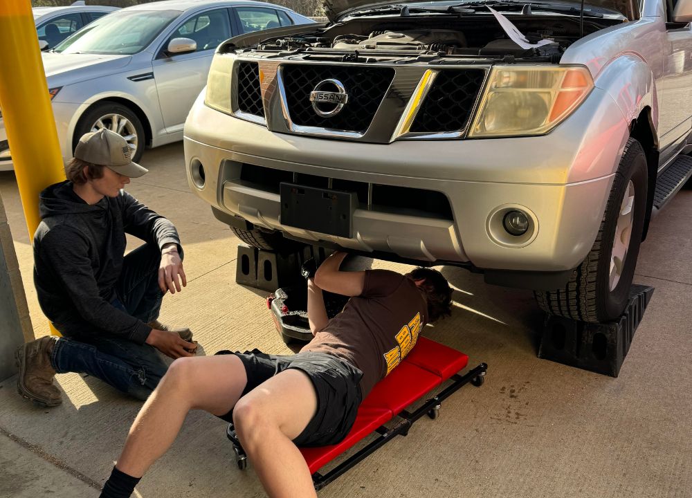 High School auto students working on car