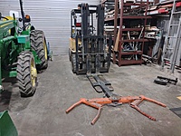 This is how we move vehicles around when they wont move themselves. It is a wheel lift system on the end of a forklift. The forklift is rated at 6000 lbs so its nothing to pick up one end and roll things around. The tractor in case you are wondering is for the back self storage lot that has a gravel parking lot and drive. 