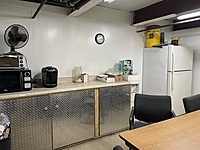 First Breakroom, downstairs on shop floor. Fridge, cupboards, Keurig, Microwave and Toaster Oven. Seats about 10 people. 