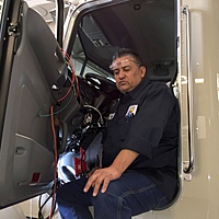 Technician José working on wiring and building an aerial bucket truck