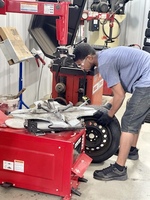 A tech training student working on a tire.