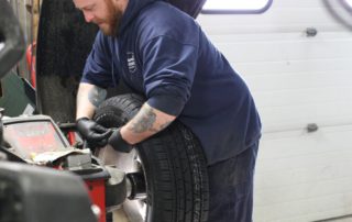 automotive technician working on a tire