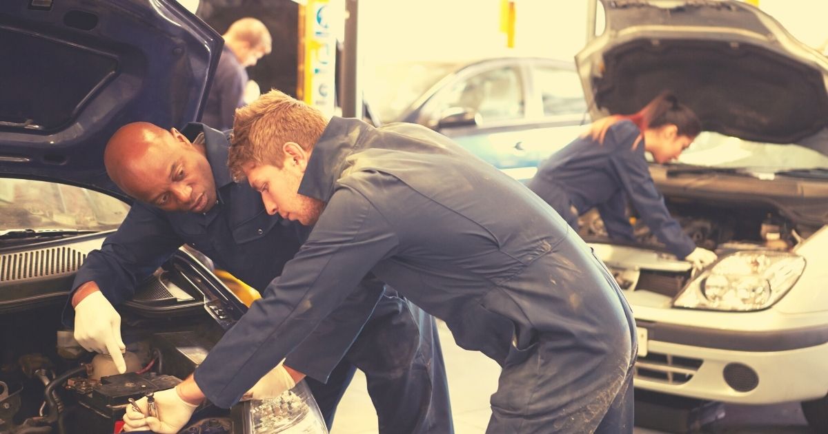 Technicians working on cars in a shop