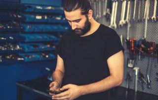 technician in a shop looking at his mobile phone