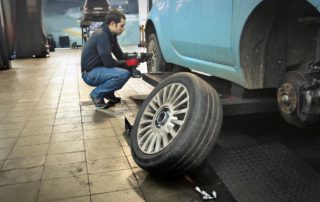 Technician changing tires on a car in a shop