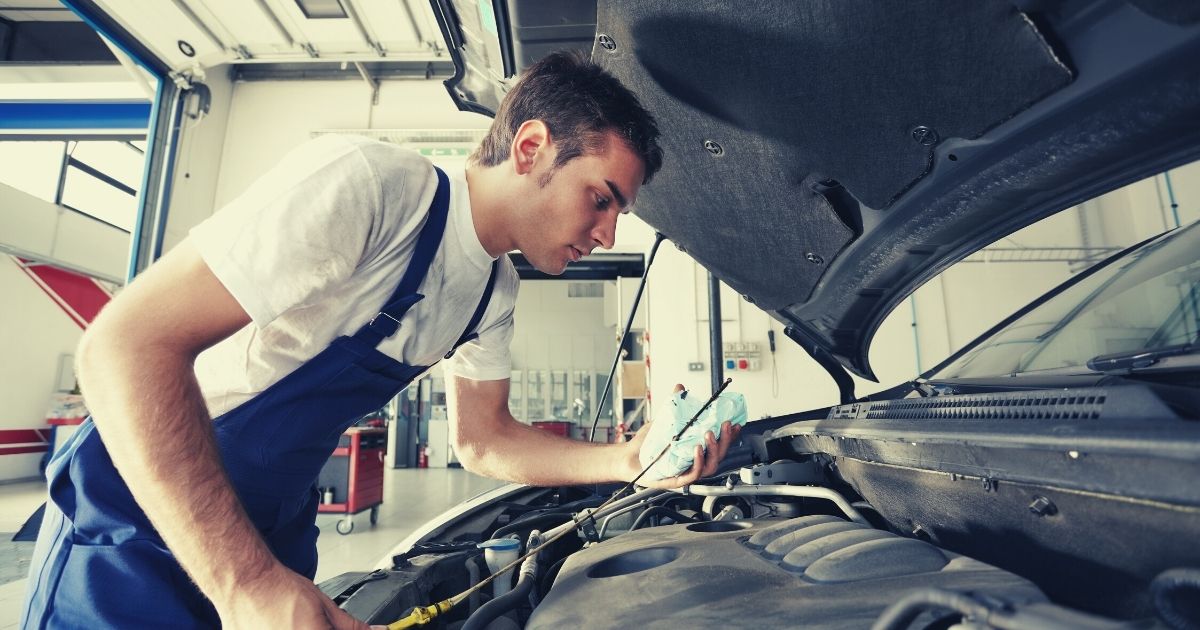 mechanic working under the hood of a car