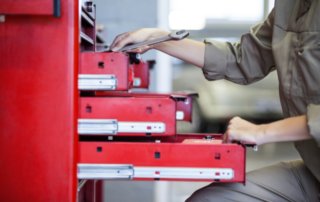 Technician grabbing tools form their red toolbox