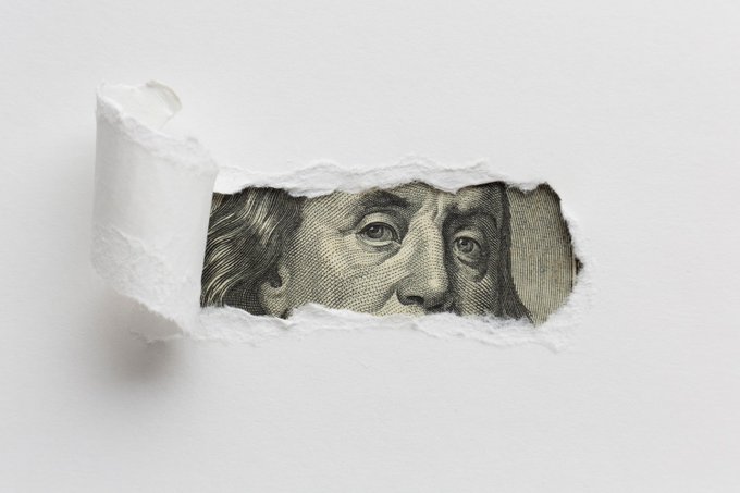 ripped paper revealing cash