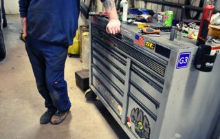 Mechanics standing next to a toolbox