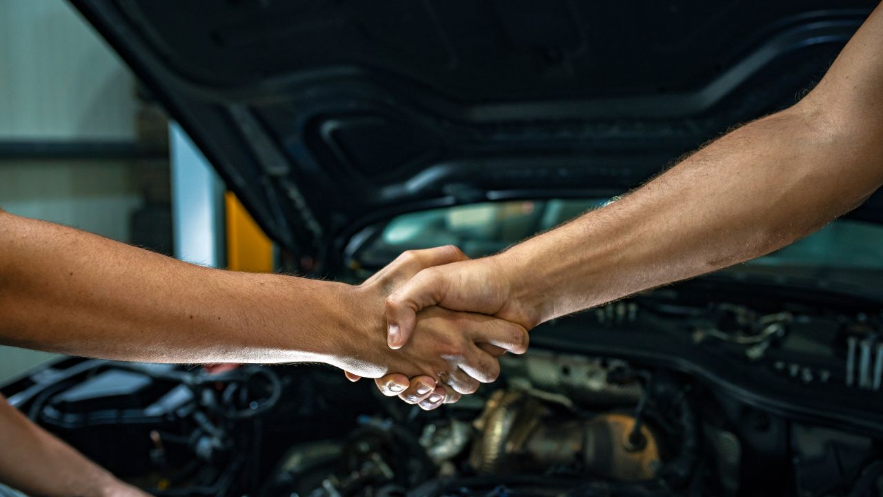 Mechanics shaking hands in an auto shop