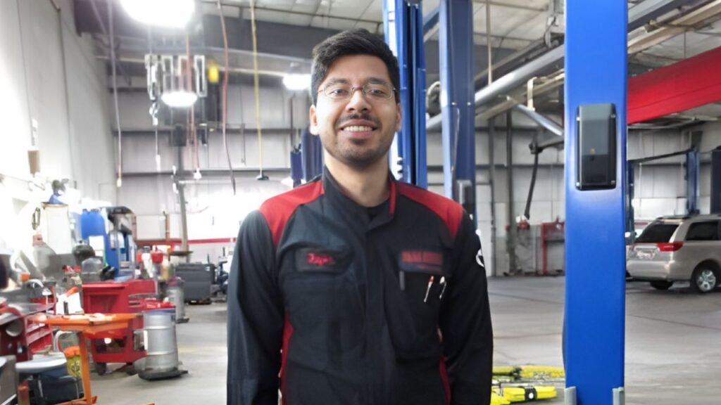 Technician in shop smiling working